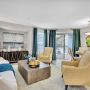 Bright living and dining area with yellow chairs, large windows, and modern decor in a cozy, open layout.